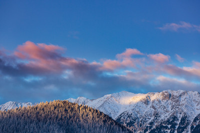 冬天的风景在山上，有白雪覆盖的山峰和落日的月亮
