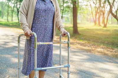 亚洲老年妇女或老年妇女患者与walker在公园散步:健康强的医疗理念