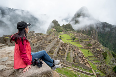 年轻的亚洲女性旅行者看着马丘比丘