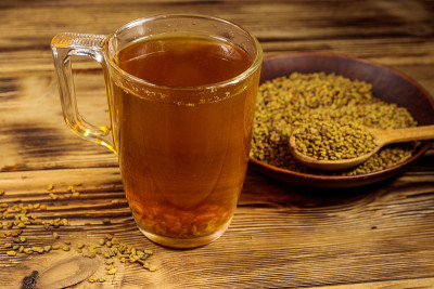 在木桌上放埃及黄茶或梅提达娜饮料和胡芦巴种子
