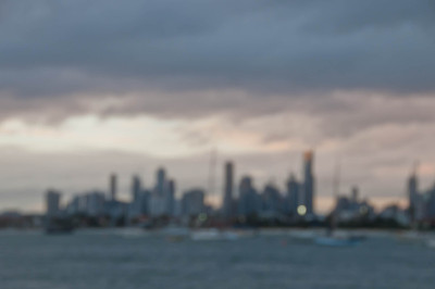 模糊抽象的夜景摩天大楼地平线与海洋和高大的办公和住宅大楼在澳大利亚墨尔本