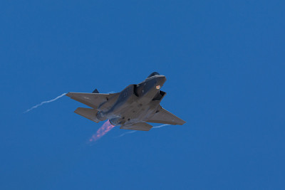 F-35闪电II接近，加力燃烧器打开，机翼尖端有冷凝尾迹