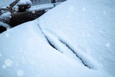 汽车玻璃和清洁刷上覆盖着冰雪。雪落。
