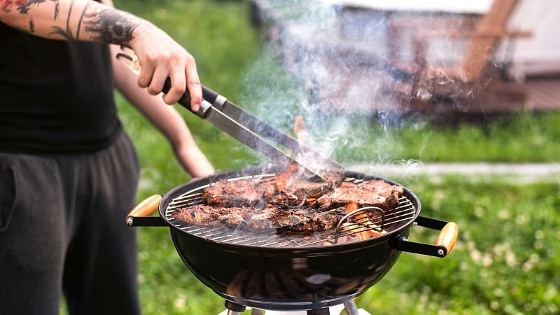 年轻人在烤架上煎肉