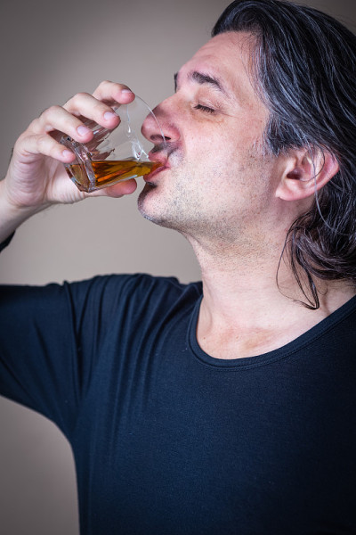 拿着一杯威士忌或波旁威士忌的男人