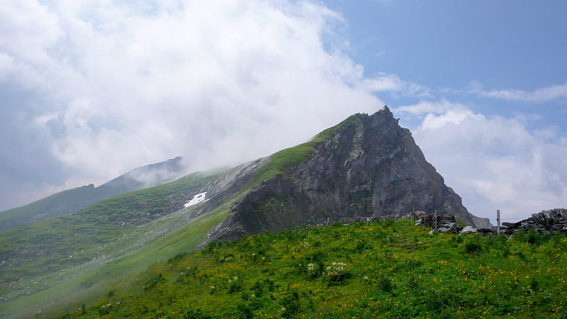 山景郁郁葱葱，峰顶有淡淡的白云和陡峭的悬崖峭壁