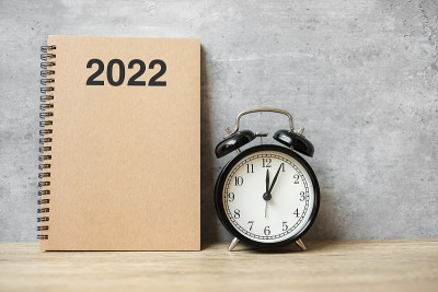 2022年新年快乐与空白笔记本，黑色复古闹钟和木制数字。倒计时，决议，目标，计划，行动和任务概念