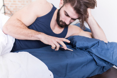 一个男人在床上用手机