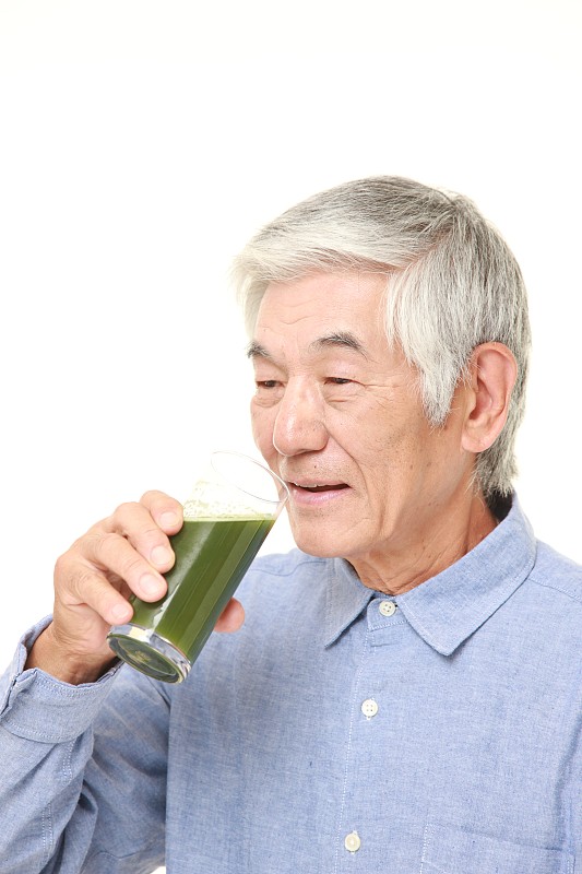 日本老男人和绿色蔬菜汁