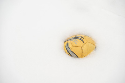 黄色的足球被雪覆盖。