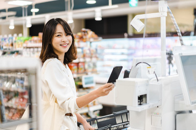 一名年轻女子在超市用智能手机支付