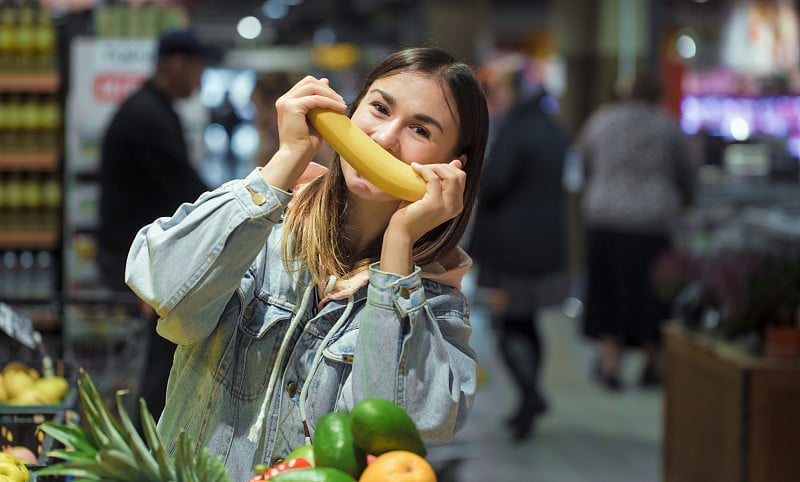 一位年轻妇女在超级市场买杂货。