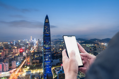 手握手机在深圳的高层建筑