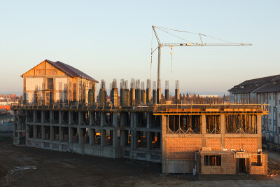 在高大的起重机前面的巨大建筑正在建设中