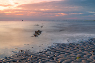 夕阳西下时，德国北部的北海海岸，长时间暴露在五彩缤纷的天空和平静的海面上