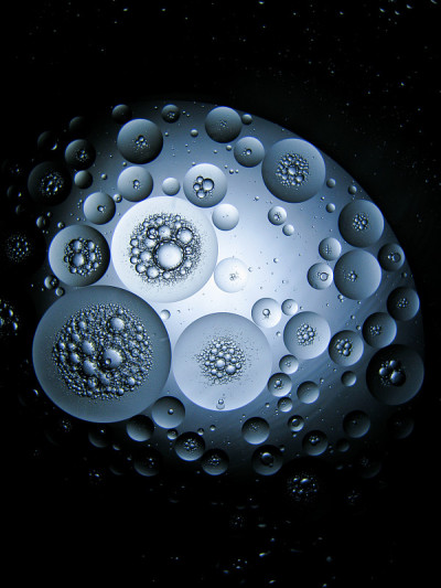 浮油滴在水面上像行星一样移动。