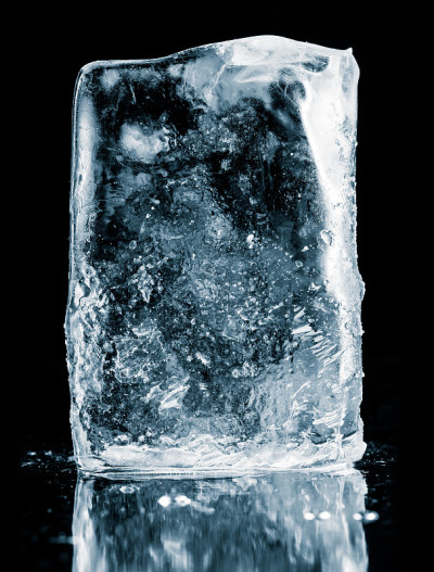 水晶透明的自然冰块上的黑色反光表面。包括剪切路径。
