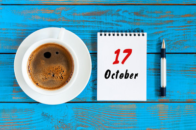 10月17日。10月17日，日历上的练习册上有咖啡杯在学生工作的背景。秋天的时间
