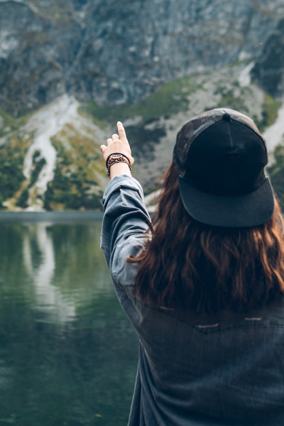 女人试图伸手到天空风景的湖在山上