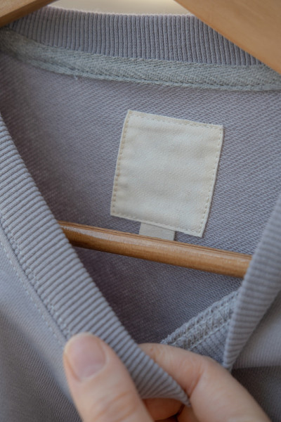浅灰色毛衣样品上的服装标签