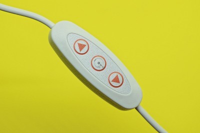 一个白色塑料电器开关，电线上有红色按钮