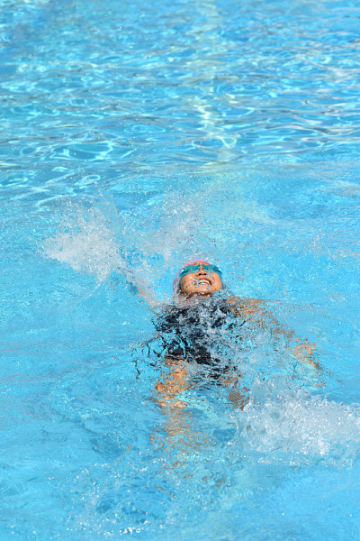 一个日本女孩正在游泳池里游仰泳