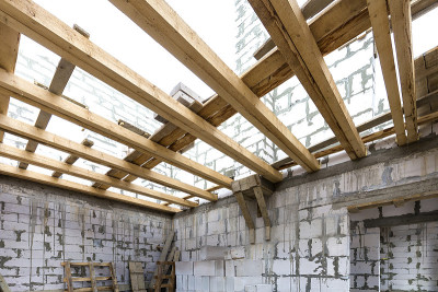 房屋内部正在建设和翻新。中空泡沫保温砌块、木质天花板梁、屋面框架等节能墙体。