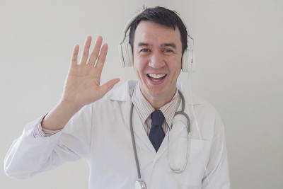 混合种族亚洲医学男性在线医生挥舞他的手和远程工作，远程健康，远程医疗，远程咨询的概念
