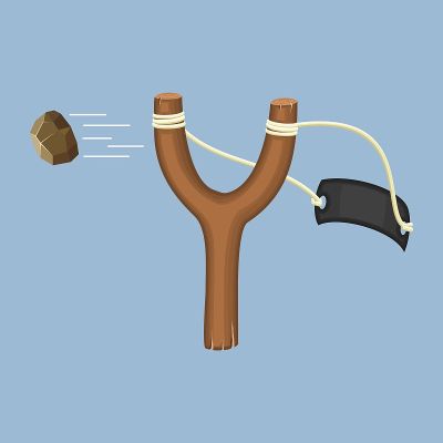 Wooden slingshot with flying stone isolated on a b