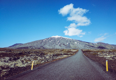 公路旅行。蓝天和一朵云。无限的道路。火山Snæfellsjökull的背景。冰岛。