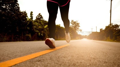 女性跑步者在公路跑道上跑步，进行马拉松和健身训练。健康的生活方式的概念。运动员在户外跑步锻炼。特写的