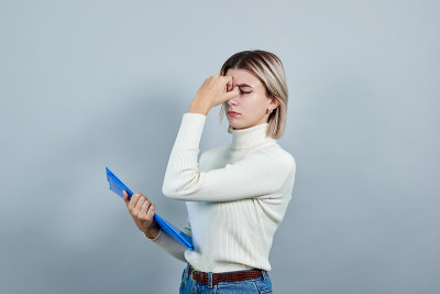 严格的女人手持夹紧鼻子孤立在灰色的墙上