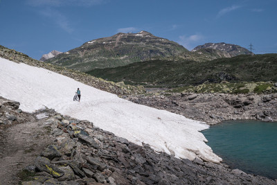 在伯尼纳山口的Lago Bianco水库骑山地自行车，越过雪地