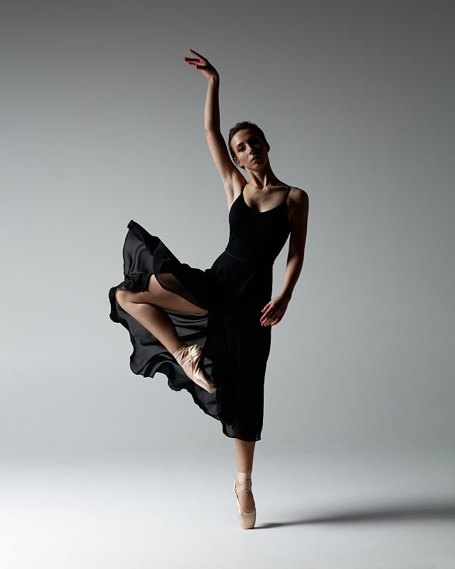 Young beautiful ballerina is posing in studio