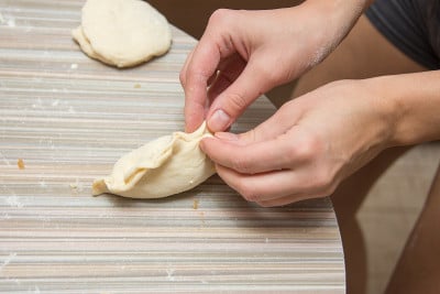女人们的手把缝饼扣在餐桌上