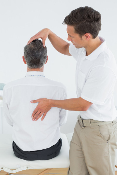 男脊椎按摩师检查成熟男子