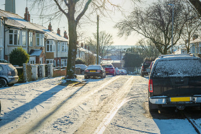 在英国，新冠肺炎封锁期间，开车行驶在英国小镇的冬季雪地路上
