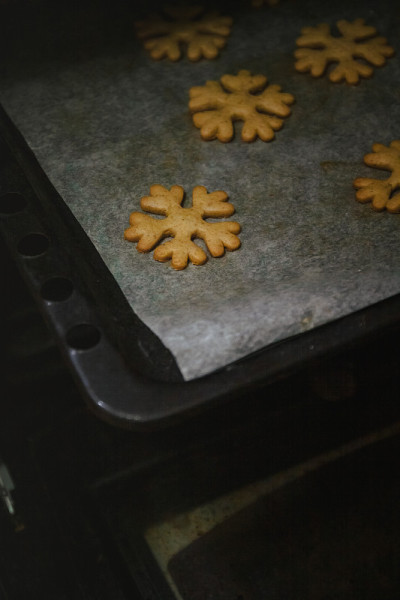 从烤箱手套里取出雪花形状的姜饼