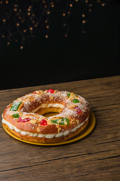 传统的西班牙圣诞食物蛋糕。Roscon de reyes背景与木制桌子上的装饰品