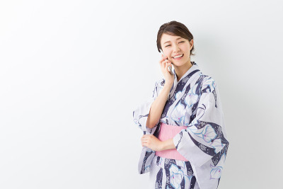 穿着和服用智能手机的女人