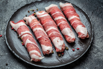 烤肉串。香肠绞碎的肉裹在培根里。食品配方的背景。近距离