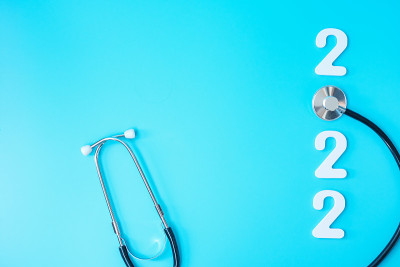 2022年健康、保险、健康、医疗理念新年快乐。听诊器和蓝色背景上的白色数字