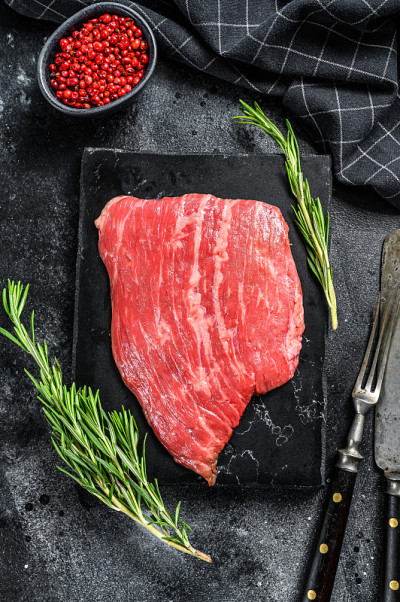 扁铁的牛排。生大理石牛肉黑安格斯。黑色背景。俯视图
