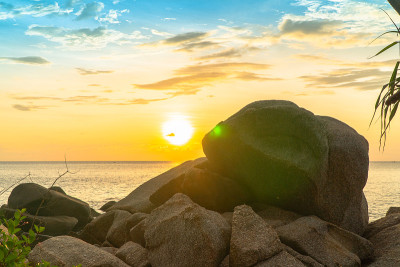 黄色的夕阳落在一块大岩石上