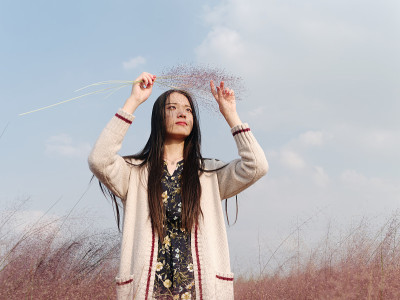美丽的中国女孩的肖像，抱着粉红色的头发在头发多的领域。