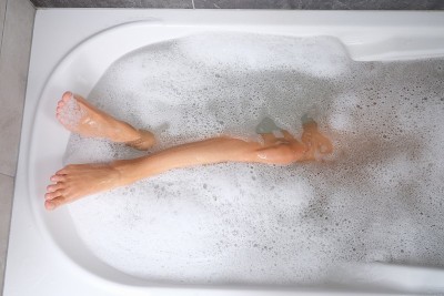 女人美丽修长的腿沐浴在水和泡沫