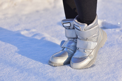 孩子们在雪地上穿着银色的冬靴