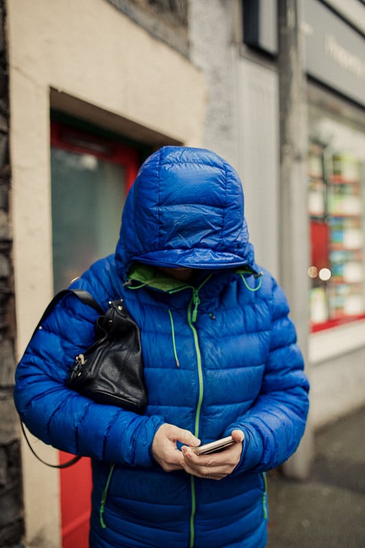 一个在雨中用手机发短信的女人