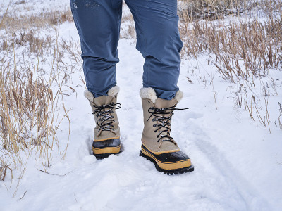 男性徒步旅行者或猎人的腿在沉重的雪地靴