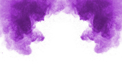粉末爆炸。一个紫色尘埃粒子爆炸的特写，孤立在白色上。